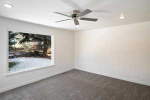 Carpeted spare room featuring ceiling fan