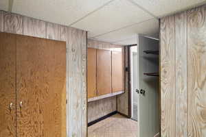 Interior space featuring a paneled ceiling and wood walls