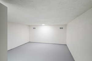 Spare room featuring concrete floors and a textured ceiling