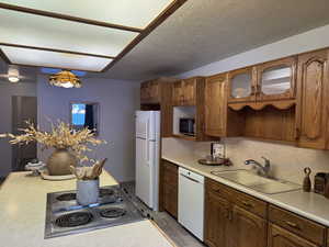 Kitchen with sink, white appliances, hardwood / wood-style floors, tasteful backsplash