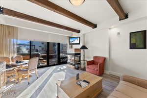 Living room featuring beamed ceiling and a multi sided fireplace