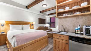 Bedroom with beamed ceiling and sink