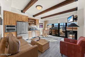 Living room with sink, beamed ceiling, and a multi sided fireplace