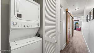 Laundry area with stacked washer and dryer