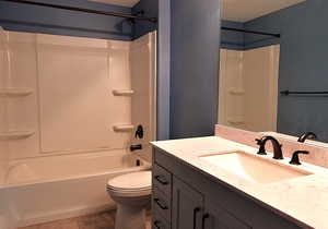 Full bathroom with tile patterned flooring, vanity, a textured ceiling, and toilet