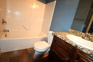 Full bathroom with vanity, toilet, tub / shower combination, and tile patterned flooring