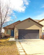 View of front of house featuring entry steps, driveway, and an attached garage