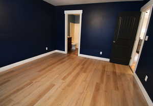 Unfurnished bedroom with connected bathroom and light hardwood / wood-style floors