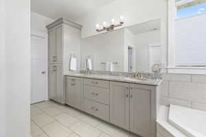 Primary Bathroom featuring tiled tub and vanity