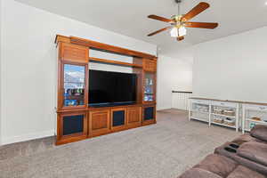 Carpeted living room with ceiling fan