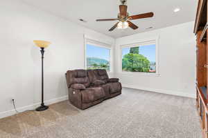 Sitting room with a mountain view, ceiling fan, and carpet flooring