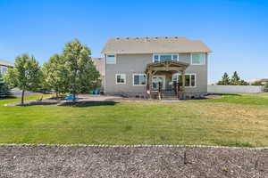 Rear view of property with a lawn