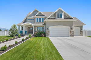 Craftsman-style house with a porch, a garage, and a front lawn