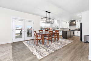 Dining space featuring french doors, dark hardwood / wood-style floors, a chandelier, and sink