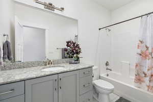 Full bathroom with vanity, toilet, and shower / bath combo