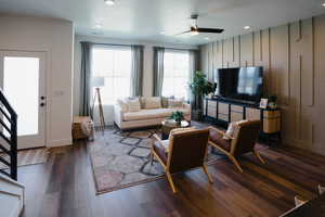 Living room with ceiling fan and dark hardwood / wood-style floors