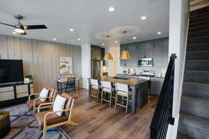 Kitchen featuring pendant lighting, ceiling fan, stainless steel appliances, dark hardwood / wood-style flooring, and decorative backsplash