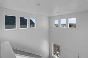 Entryway with a towering ceiling, plenty of natural light, and carpeted stairs