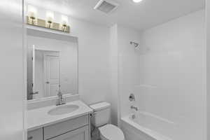 Full bathroom with toilet, vanity, and  shower combination