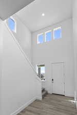 Entryway with a towering ceiling, plenty of natural light, and light hardwood / wood-style flooring