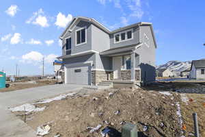 View of front facade with a garage and a mountain view