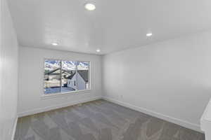 Office space with light carpet and a textured ceiling