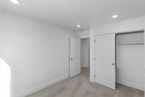 Bedroom 3 with light colored carpet and a closet