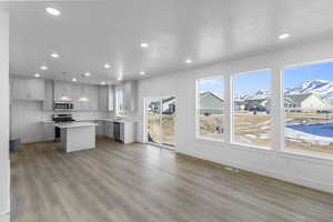 Living room with a mountain view, wood-type flooring, and large windows