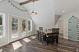 Dining area featuring vaulted ceiling with beams, dark hardwood / wood-style floors, and french doors