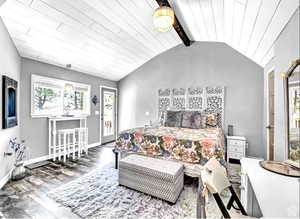 Bedroom with hardwood / wood-style floors, access to outside, and lofted ceiling with beams