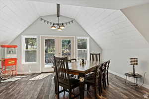 Dining room with vaulted ceiling with beams, a wealth of natural light, and dark hardwood / wood-style flooring