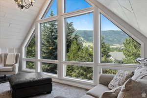 Sunroom featuring vaulted ceiling, a mountain view, plenty of natural light, and wooden ceiling