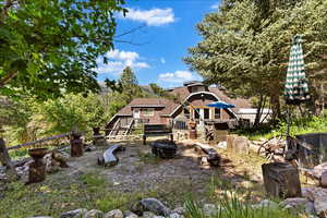 Back of property featuring a wooden deck and an outdoor fire pit