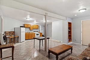 Living room featuring built in features, sink, a textured ceiling, and light tile patterned floors