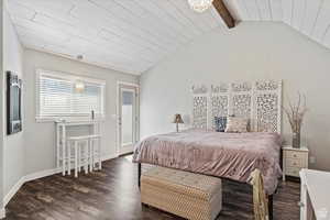 Bedroom with access to exterior, dark wood-type flooring, and lofted ceiling with beams