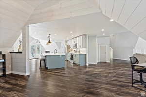 Interior space with vaulted ceiling, sink, and dark hardwood / wood-style flooring