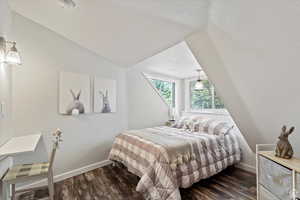 Bedroom featuring vaulted ceiling and dark hardwood / wood-style floors