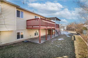 Back of house featuring a wooden deck, a yard, and a patio area