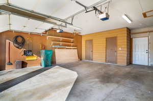 Garage featuring a garage door opener and wooden walls