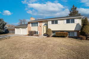 Bi-level home with a garage and a front yard