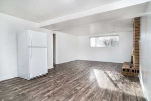 Unfurnished living room featuring dark wood-type flooring