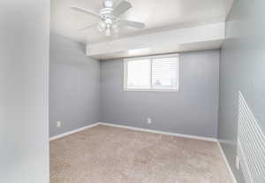 Empty room with light colored carpet and ceiling fan