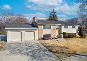 Bi-level home with a mountain view, a garage, and a front yard