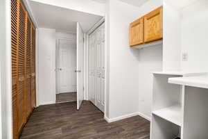 Hallway with dark wood-type flooring and a textured ceiling