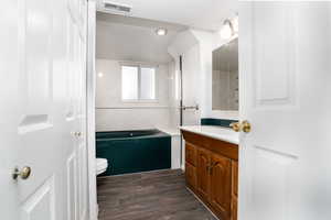 Bathroom with hardwood / wood-style flooring, vanity, a textured ceiling, and toilet