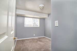 Empty room featuring carpet floors and a textured ceiling