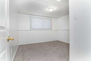 Carpeted empty room featuring a textured ceiling