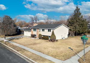 Bi-level home with a garage and a front lawn