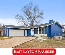 View of front of property featuring a garage, fence, concrete driveway, a front lawn, and a chimney