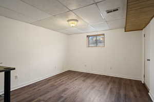 Basement bedroom with wood-style floors.